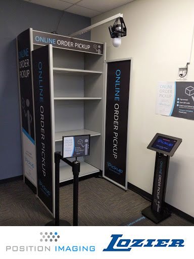 Position Imaging and Lozier online order pickup demo station with branded shelving, overhead camera, and check-in kiosk
