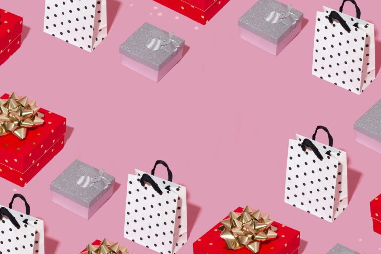 Pattern of red gift boxes and polka-dot shopping bags on a pink background
